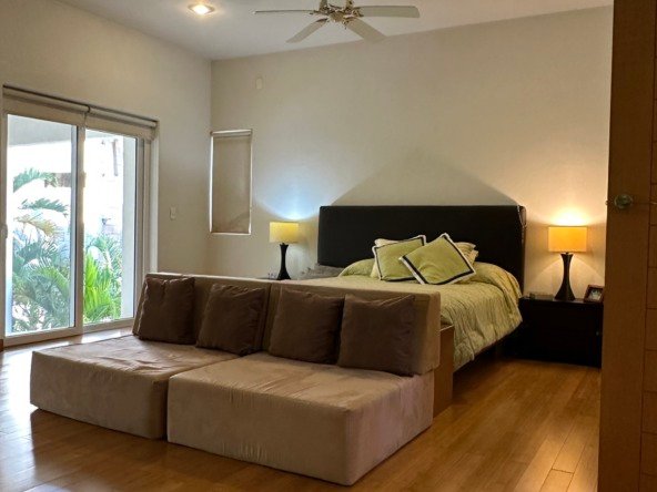 Casa en venta en lagos del sol cancun - Recámara luminosa con piso de madera y luces cálidas
