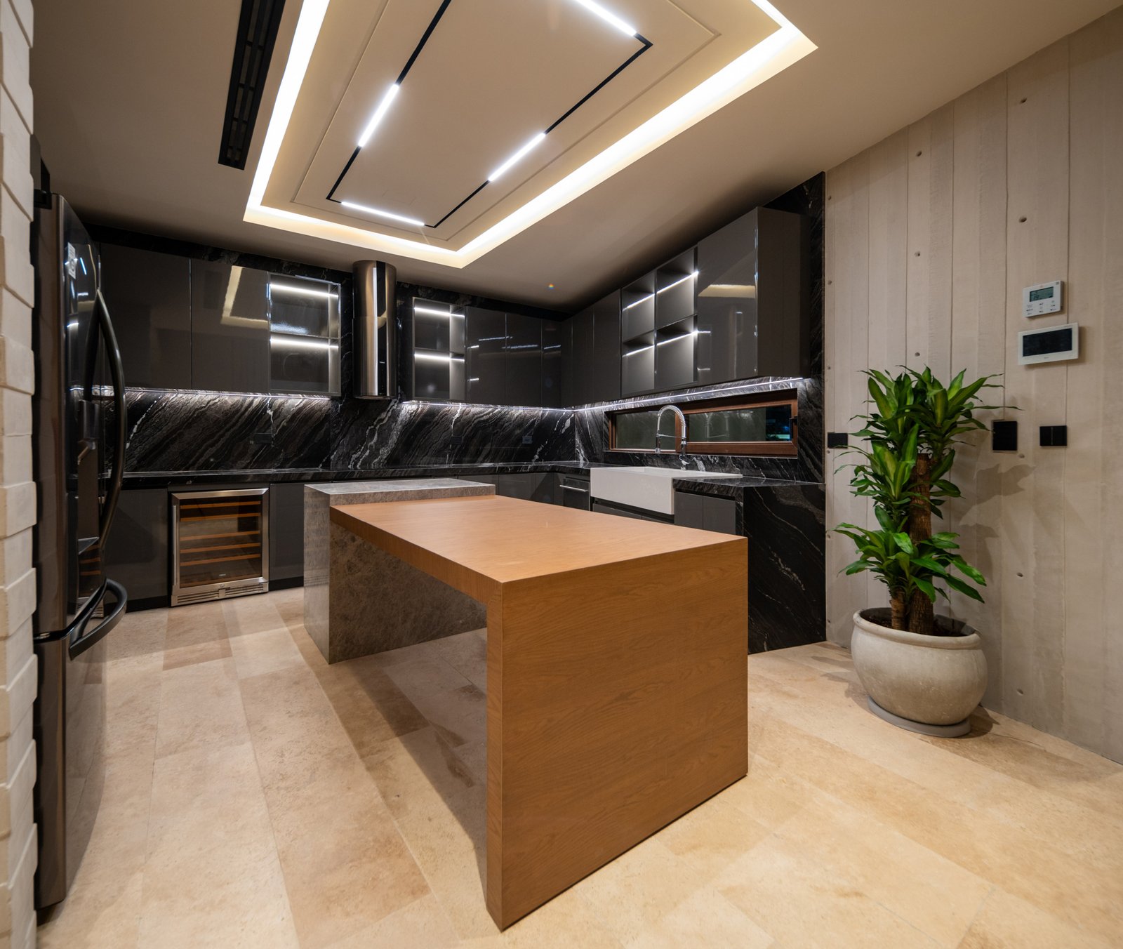 Casa en venta en puerto cancún - cocina con isla central,encimeras de mármol negro y una iluminación contemporánea en el techo