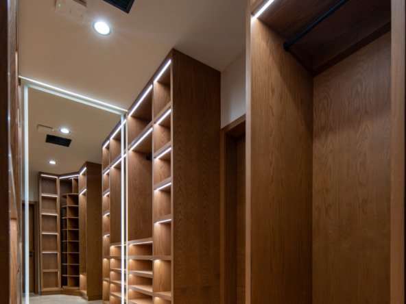 Casa en venta en puerto cancún - Vestidor con amplios estantes y cajones de madera, iluminado con luces LED integradas