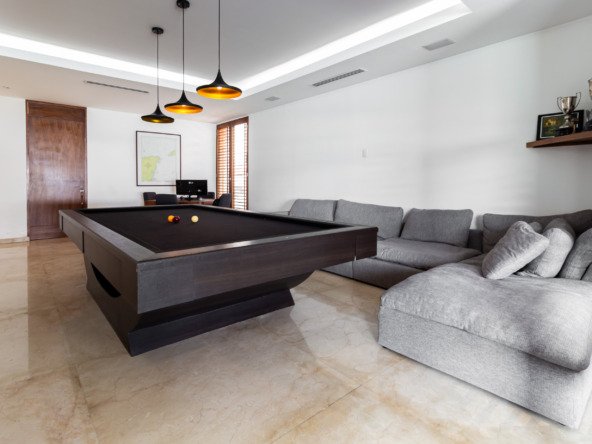 Casa venta isla dorada zona hotelera cancún-sala de juegos con una mesa de billar moderna de madera oscura y luces colgantes
