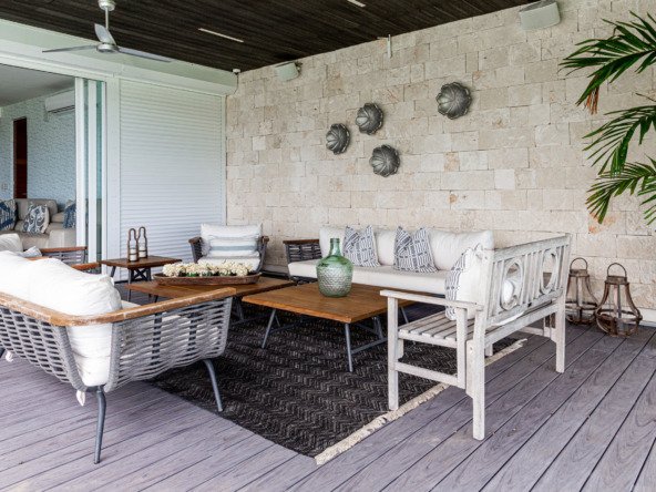 Casa venta isla dorada zona hotelera cancún - espacio exterior techado con sofás blancos, sillas de ratán y mesas de madera