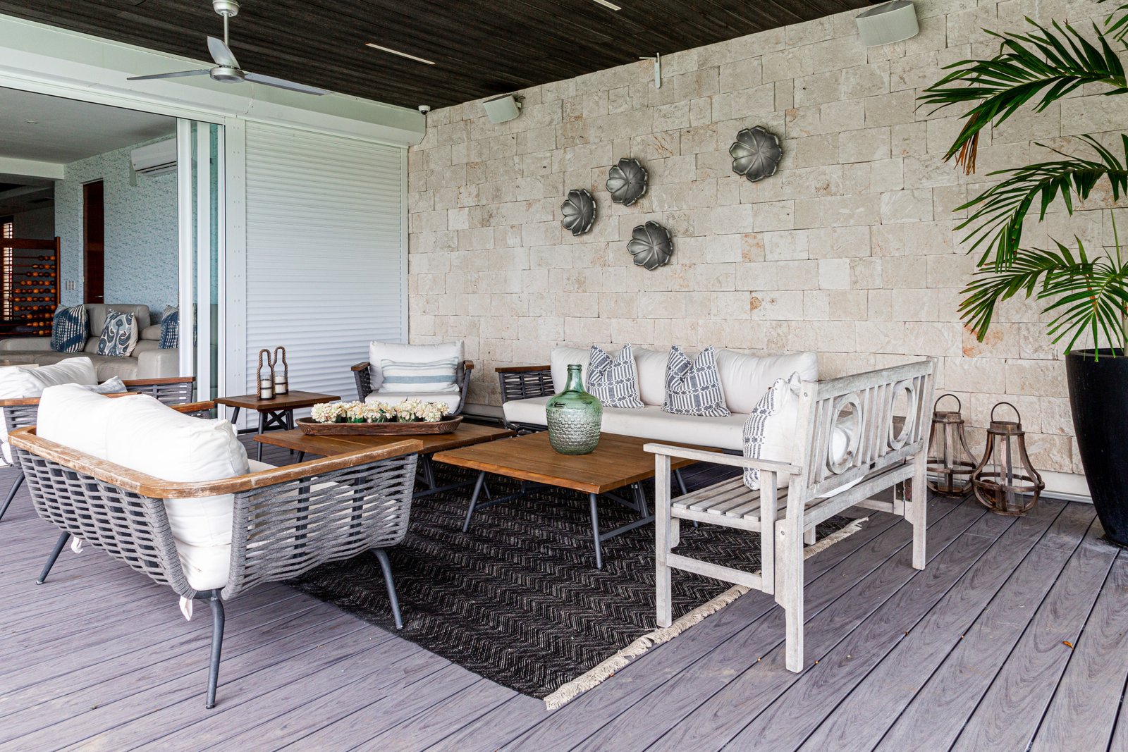 Casa venta isla dorada zona hotelera cancún - espacio exterior techado con sofás blancos, sillas de ratán y mesas de madera