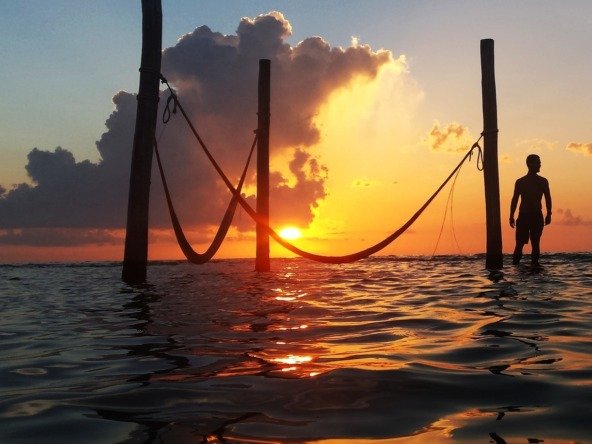 Terreno en venta en isla holbox - atardecer en el mar, con hamacas sobre el agua